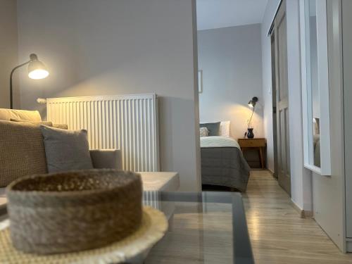a living room with a bed and a glass table at APARTAMENTY LAVENDERIA z widokiem na Górę Parkową, blisko centrum in Kudowa-Zdrój