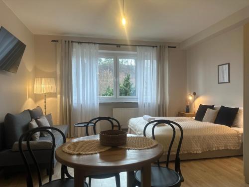 a bedroom with a bed and a table and chairs at APARTAMENTY LAVENDERIA z widokiem na Górę Parkową, blisko centrum in Kudowa-Zdrój