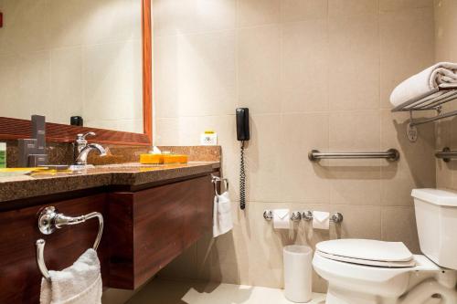 a bathroom with a toilet and a sink and a phone at Marriott Venezuela Hotel Playa Grande in Playa Grande