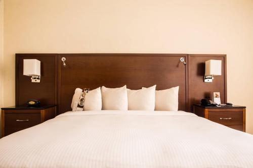 a bedroom with a large bed with white sheets and pillows at Marriott Venezuela Hotel Playa Grande in Playa Grande