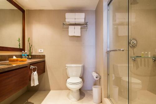 a bathroom with a toilet and a glass shower at Marriott Venezuela Hotel Playa Grande in Playa Grande