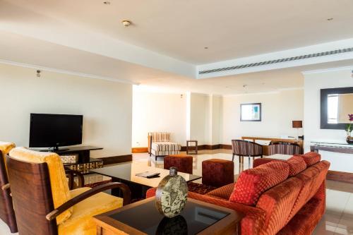 a living room with a couch and a tv at Marriott Venezuela Hotel Playa Grande in Playa Grande
