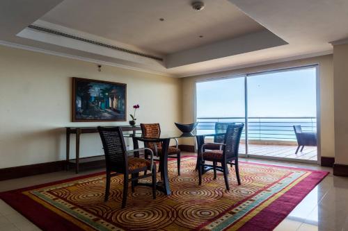 a dining room with a table and chairs and a large window at Marriott Venezuela Hotel Playa Grande in Playa Grande