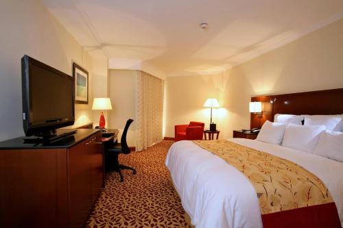 a hotel room with a bed and a flat screen tv at Marriott Venezuela Hotel Playa Grande in Playa Grande