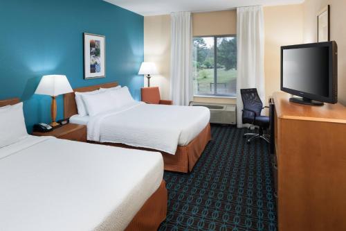 a hotel room with two beds and a flat screen tv at Fairfield by Marriott Ruston in Ruston