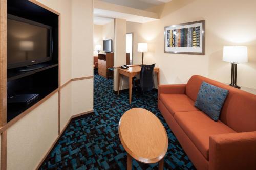 a hotel room with a couch and a television at Fairfield by Marriott Ruston in Ruston