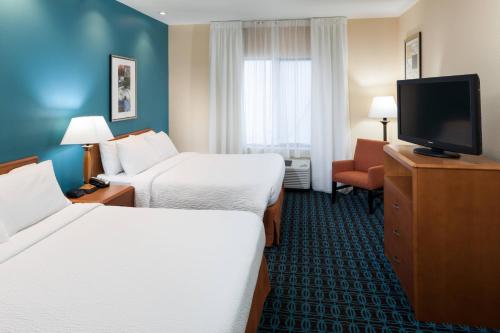 a hotel room with two beds and a flat screen tv at Fairfield by Marriott Ruston in Ruston