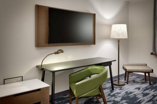 a room with a desk and a chair and a tv at Fairfield Inn & Suites by Marriott Fort Smith in Fort Smith