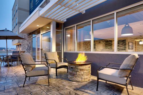 a fire pit on a patio with chairs and a building at Fairfield Inn & Suites by Marriott Fort Smith in Fort Smith