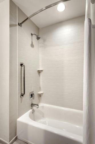 a white bathroom with a tub and a shower at Fairfield Inn & Suites by Marriott Fort Smith in Fort Smith