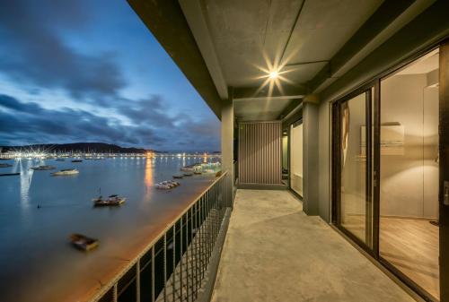 a balcony with a view of the water and boats at SHIN Arch39 Phuket Beach Front - SHA Plus in Chalong 