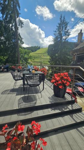 a deck with a table and chairs and flowers at Синя гора in Bukovel