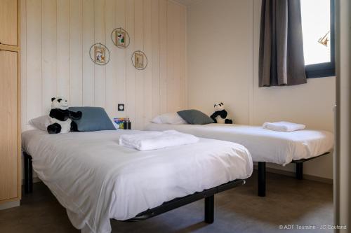 two beds with stuffed animals on them in a room at Cottages du Golf Fleuray-Amboise in Cangey
