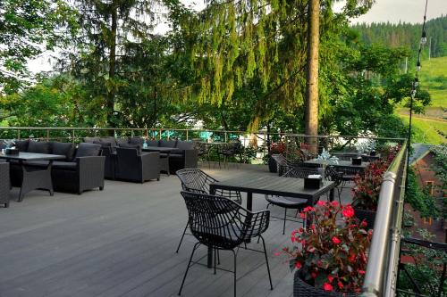 a patio with tables and chairs on a deck at Синя гора in Bukovel