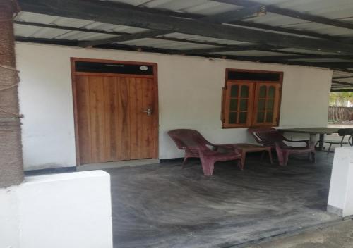 a room with a table and chairs and a wooden door at Skykite Resort & Hostel Kalpitiya Sri Lanka in Kalpitiya