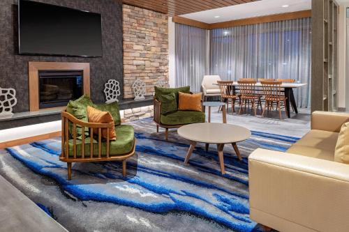 a living room with furniture and a dining room at Fairfield Inn & Suites by Marriott Queensbury Glens Falls/Lake George in Queensbury