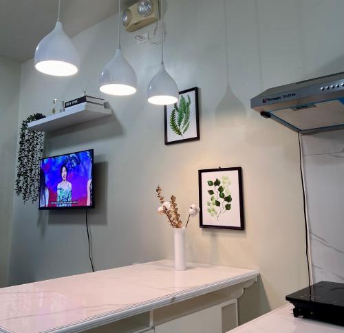 a room with a tv and flowers on the wall at 2 Bedroom Condo Unit with Balcony Amaia Steps Altaraza in Tunkong Manga