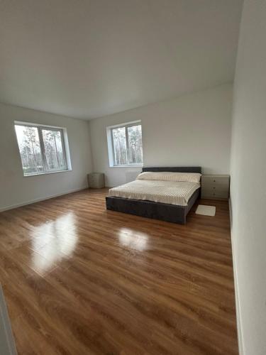 a bedroom with a bed and a wooden floor at By Room in Rumbula