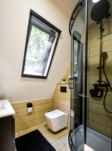 a bathroom with a toilet and a window at Forest Escape with Jacuzzi & Pool Among the Trees by Destination GREEN Croatia in Ivanec