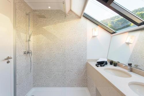een badkamer met een wastafel, een douche en een raam bij Four Points by Sheraton Sesimbra in Sesimbra