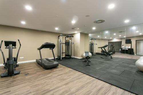 a gym with treadmills and exercise equipment in a room at Four Points by Sheraton Sesimbra in Sesimbra