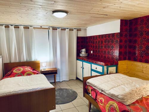 - une chambre avec 2 lits dans une pièce aux murs rouges dans l'établissement Centre de Luchon grand Appartement rénové, à Luchon