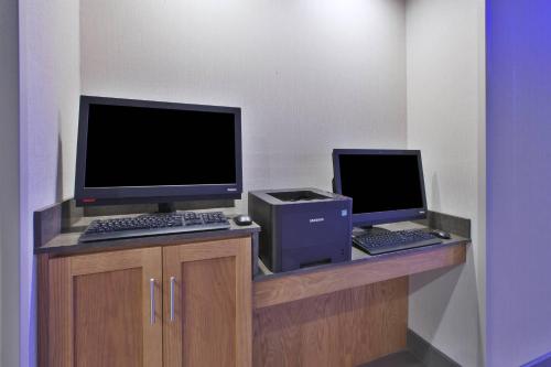a desk with a computer and a monitor and keyboard at Fairfield Inn & Suites by Marriott Flint Grand Blanc in Grand Blanc