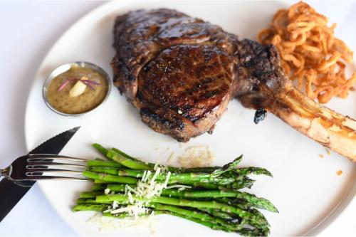a plate of food with a steak and asparagus at Four Points by Sheraton Detroit Novi in Novi