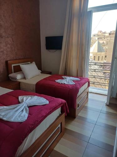 a hotel room with two beds and a window at Meramees Hotel in Cairo