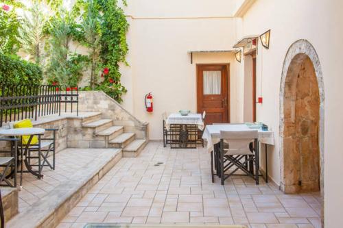 an outdoor patio with tables and chairs and a door at Calergi Residence - Holidays in Crete in Atsipopoulo