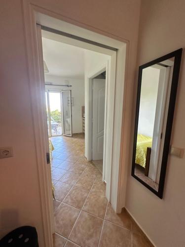 a hallway with a mirror and a tile floor at Seapine Studios in Lassi