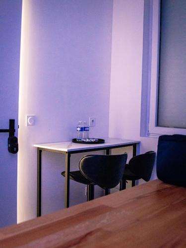 a table with two chairs and a bottle of water on it at Suite KING Size SAUNA JACUZZI in Lisieux