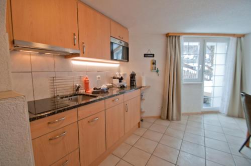 a kitchen with wooden cabinets and a sink at Chalet Aeschhorn in Zermatt