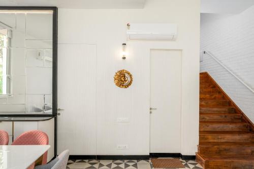 a hallway with a white door and a staircase at Verona by Vianaar Luxe Garden Pool Villa Assagao in Goa