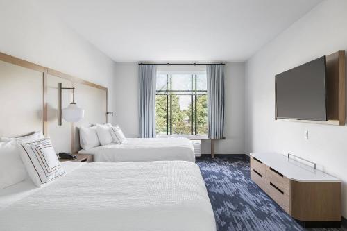 a hotel room with two beds and a flat screen tv at Fairfield Inn & Suites by Marriott Minneapolis North/Blaine in Blaine