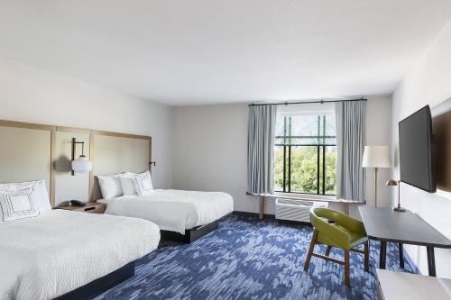 a hotel room with two beds and a desk and a television at Fairfield Inn & Suites by Marriott Minneapolis North/Blaine in Blaine