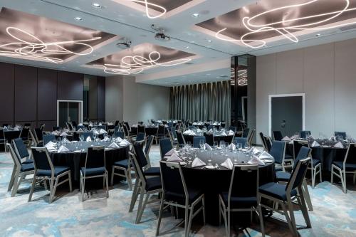 a ballroom with tables and chairs and a large room with at Four Points by Sheraton Auckland in Auckland