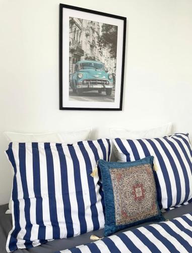 un canapé avec des coussins rayés et une photo de voiture dans l'établissement Spacious &nice apartment with balcony and parking, à Villeurbanne