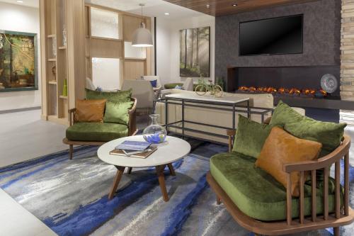 a living room with two chairs and a fireplace at Fairfield Inn & Suites by Marriott Fort Collins South in Fort Collins