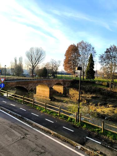 a bridge over a river next to a road at la Brunita in Rubiera