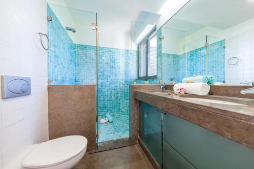 une salle de bain avec toilettes et douche en verre dans l'établissement Townhouse Ocean Joy by Algarve Vacation, à Albufeira