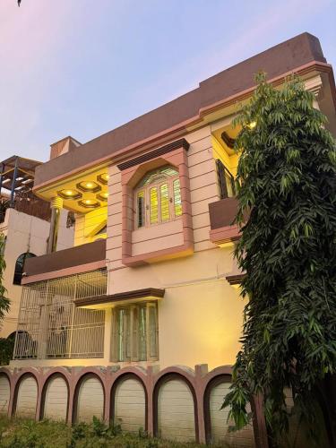 a yellow house with a tree in front of it at The Tranquil Stay in kolkata