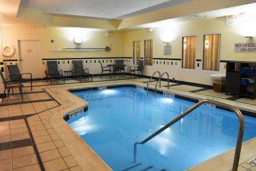 a pool in a hotel room with tables and chairs at Fairfield Inn and Suites by Marriott Strasburg Shenandoah Valley in Strasburg