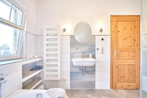 a bathroom with a sink and a mirror at Am Redensee in Fuhlendorf
