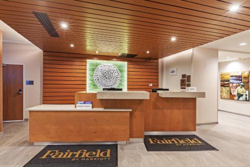 a lobby with a reception desk and wooden walls at Fairfield Inn & Suites by Marriott Tulsa Catoosa in Catoosa