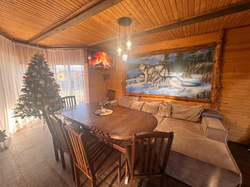 a dining room with a table and a christmas tree at Villa Zgarda1 in Mykulychyn