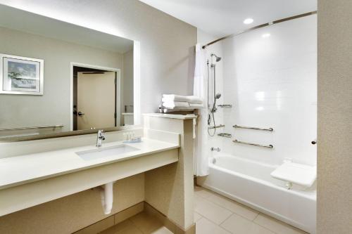 a bathroom with a sink and a tub and a mirror at Fairfield Inn & Suites by Marriott Springfield North in Springfield