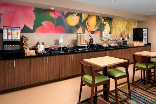 a restaurant with a bar with chairs and a counter at Fairfield Inn & Suites by Marriott Albuquerque Airport in Albuquerque