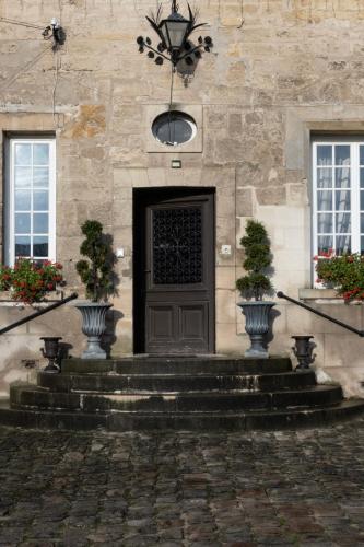 a building with a door with two vases on the stairs at Maison Prieuré in Borest