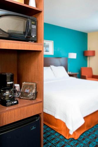 a hotel room with a bed and a microwave at Fairfield Inn & Suites South Bend Mishawaka in South Bend